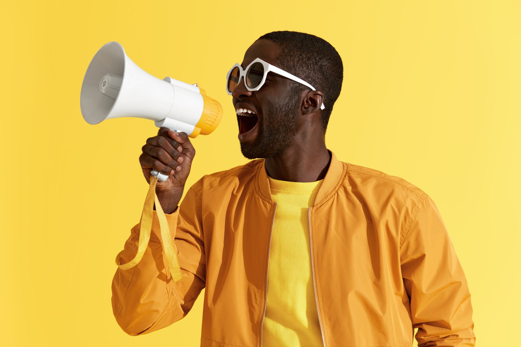 Advertising. Man screaming announcement in megaphone portrait